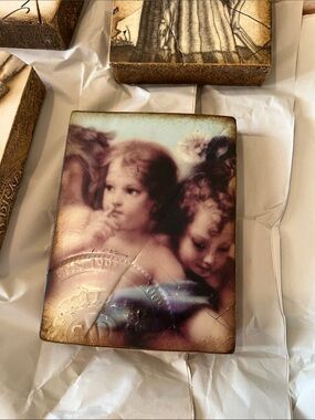 Sid Dickens Cherub Plaque in Cream, Brown and Blue Tones